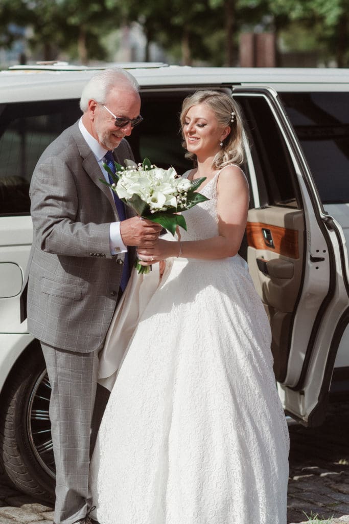 father-of-bride-helping-bride-out-of-limo