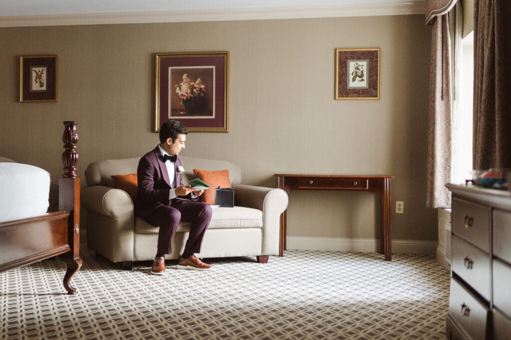groom-opening-gift-in-hotel-suite-at-the-madison-hotel-nj