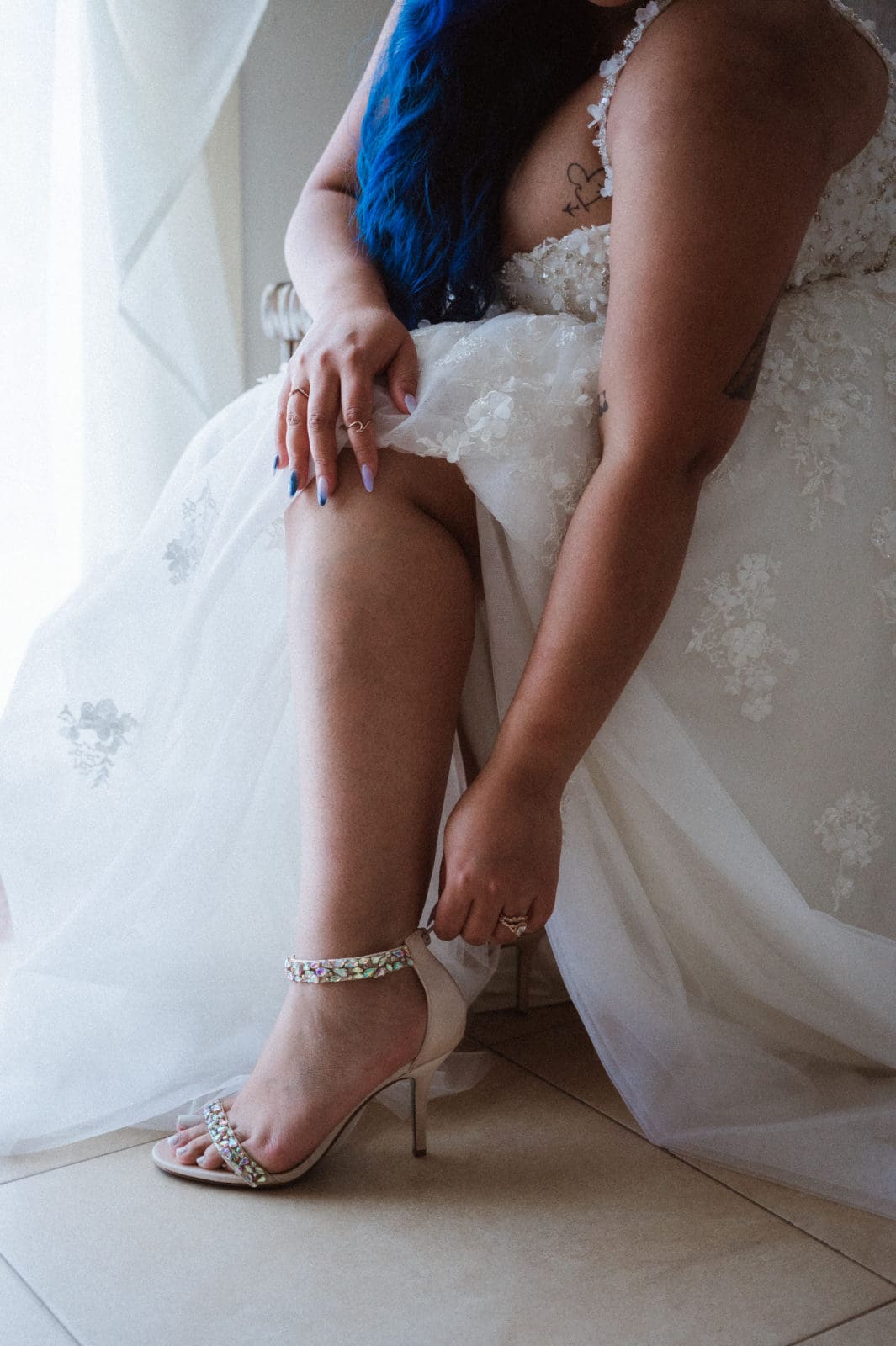 bride-with-blue-hair-putting-on-heels-shoes-by-suess-moments-weddnig-photographer