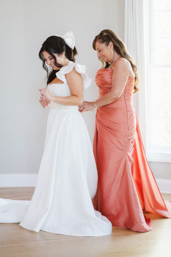 mother-of-bride-getting-the-bride-dressed-on-wedding-day