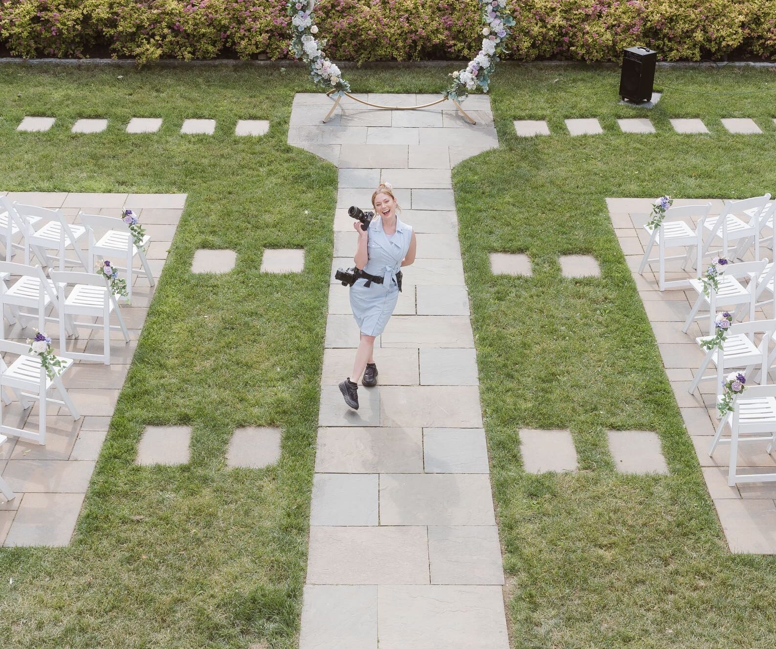 Wedding photographer Suess Moments captured at wedding ceremony wearing blue dress