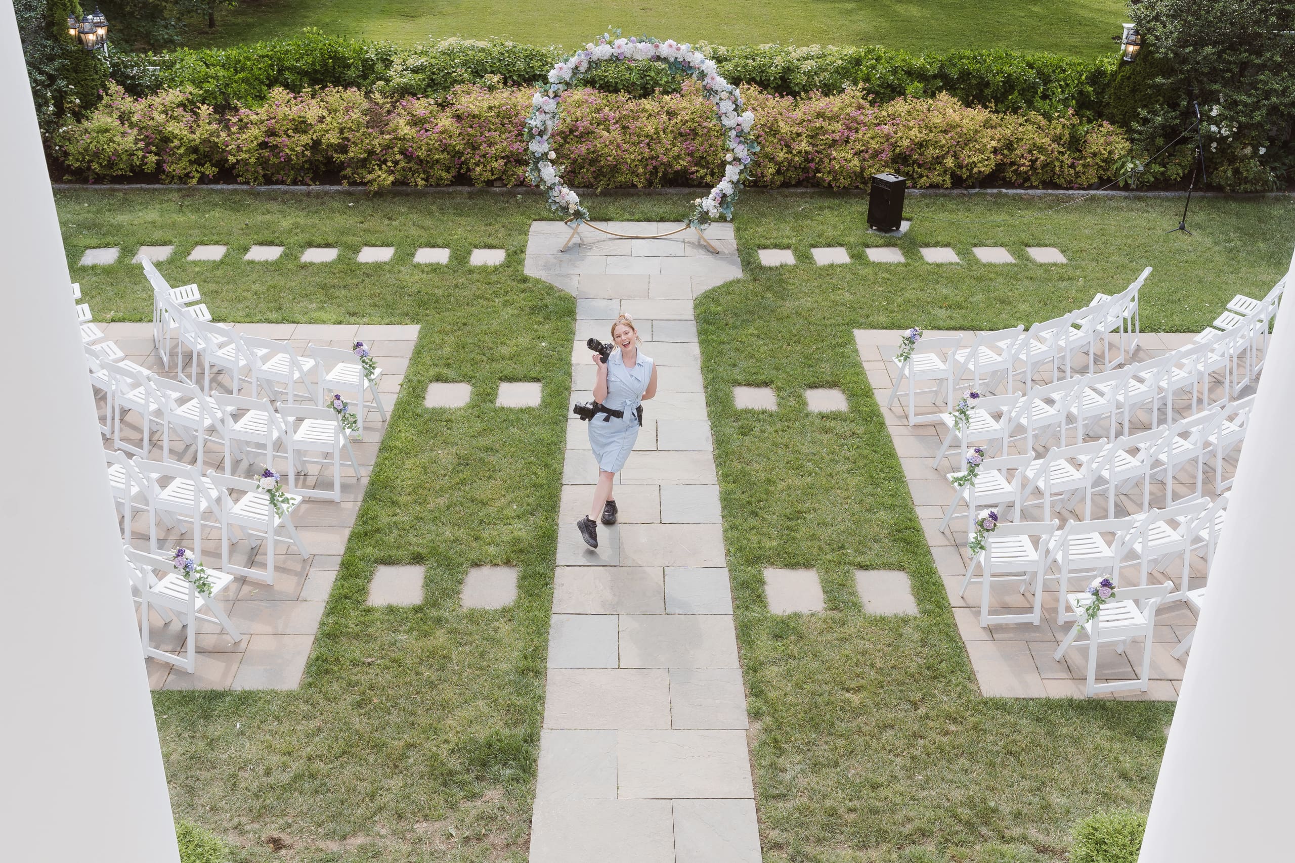 Wedding photographer Suess Moments captured at wedding ceremony wearing blue dress