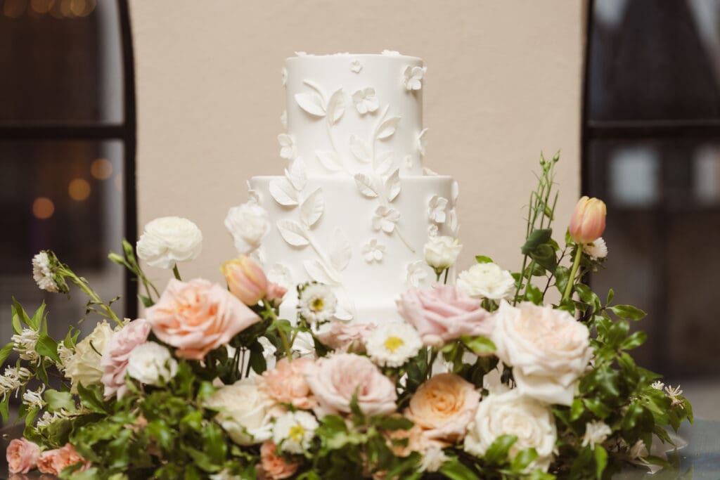 beautiful wedding cake with carvings of flowers all white