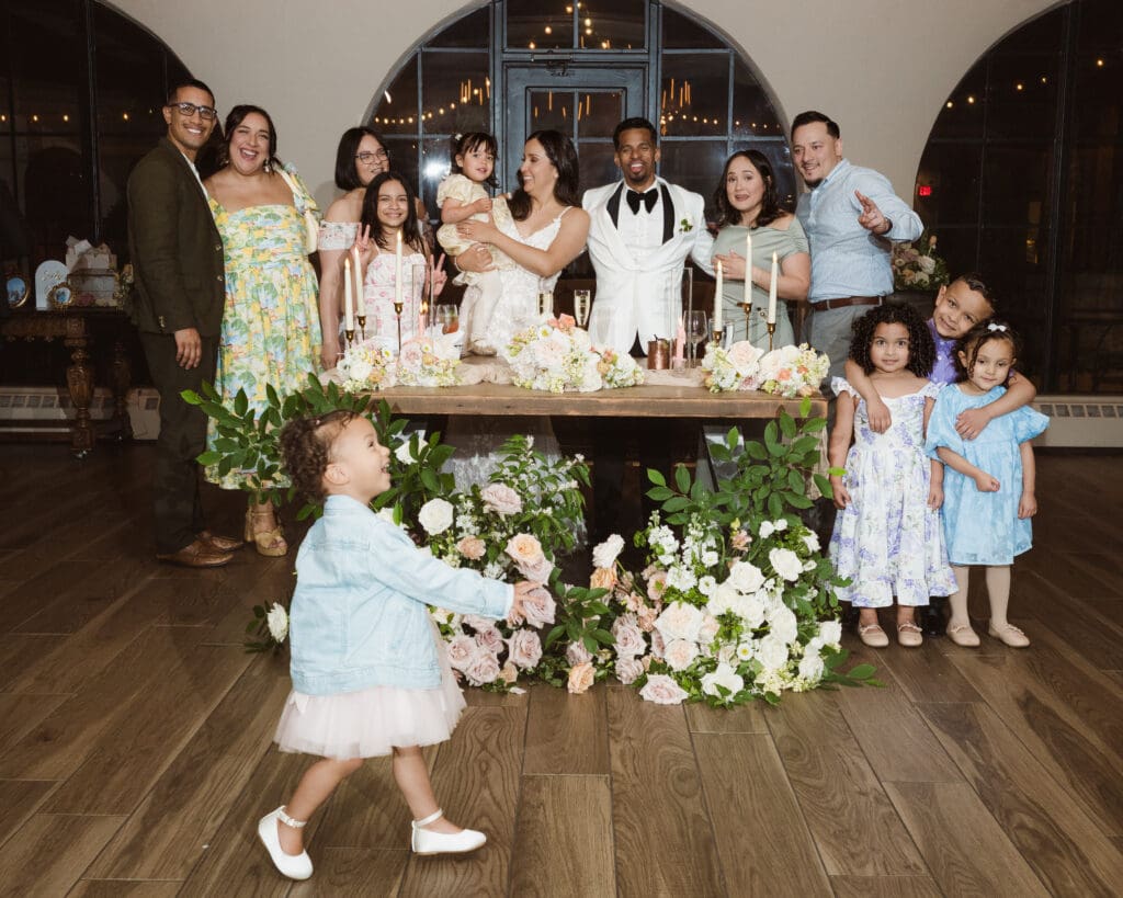 funny wedding photo of flower girl photo bombing family photo