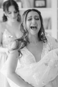 bride getting ready with the help from mom and maid of honor