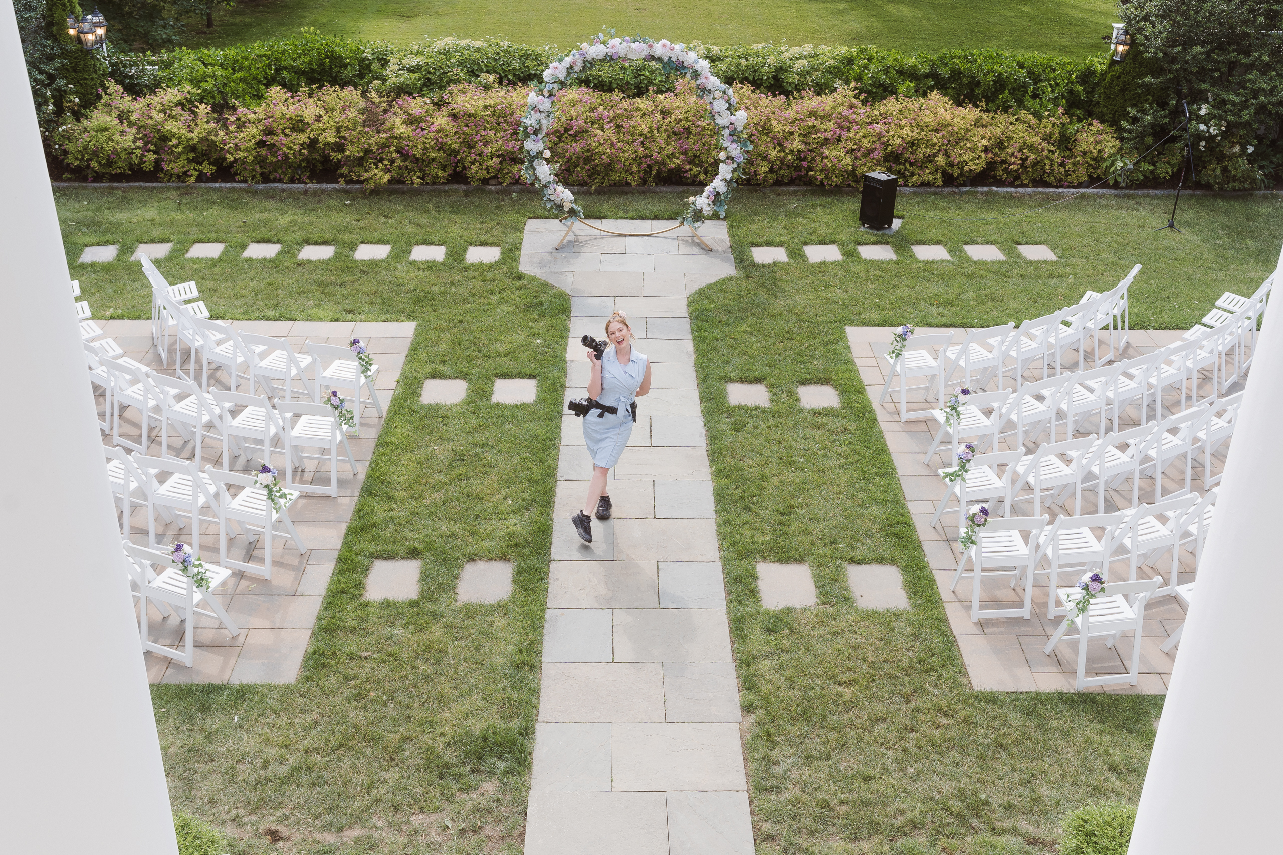 Wedding photographer Suess Moments captured at wedding ceremony wearing blue dress